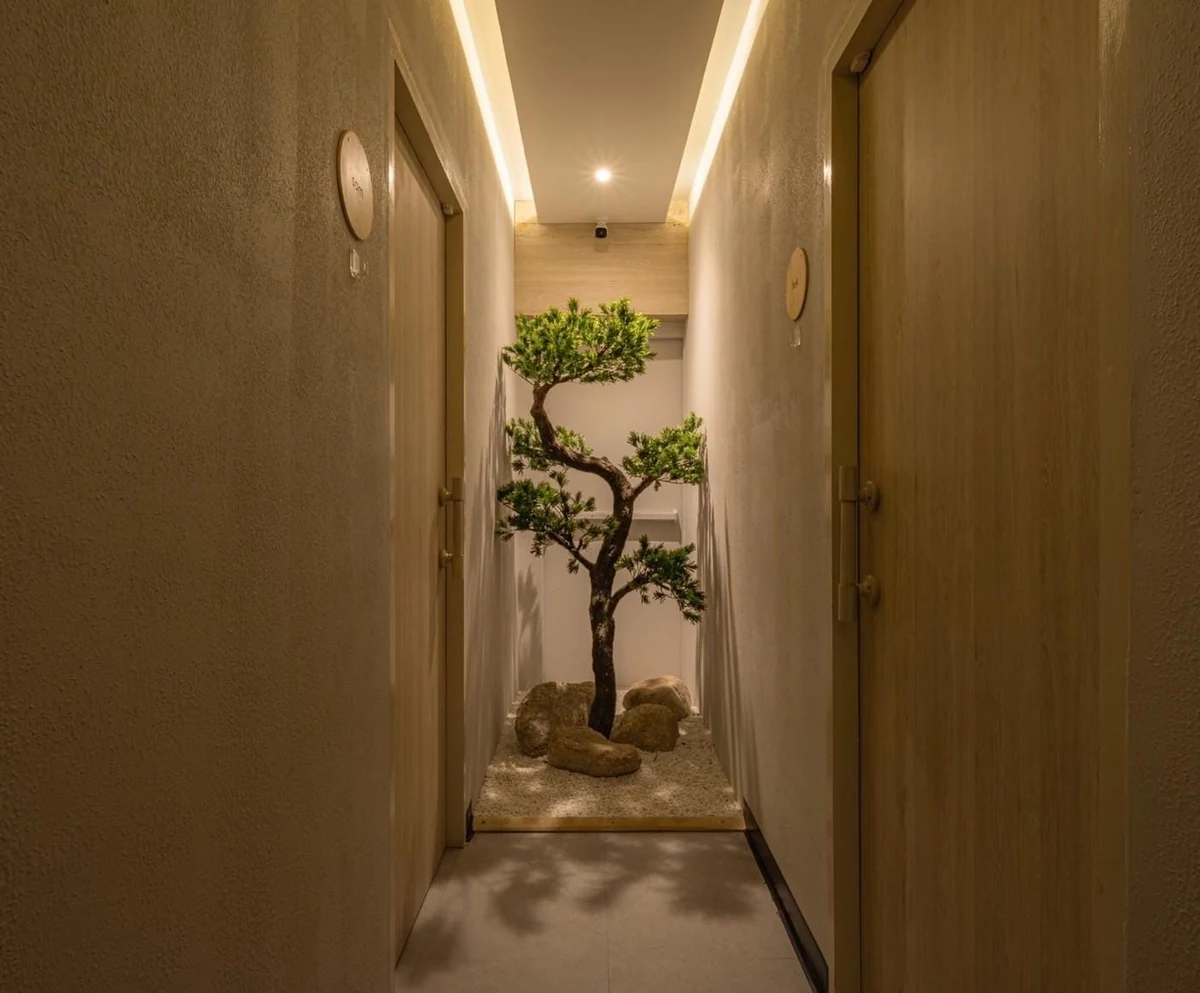 Open glass-fronted corridor of a licensed massage in Siam Bangkok shop with a posted treatment menu visible from the pavement