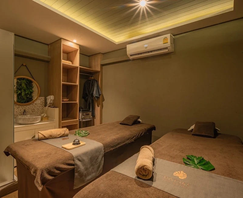 Private treatment room with a low massage bed and folded towels at Nature Thai Massage on Siam Square Soi 5, a massage in Siam Bangkok